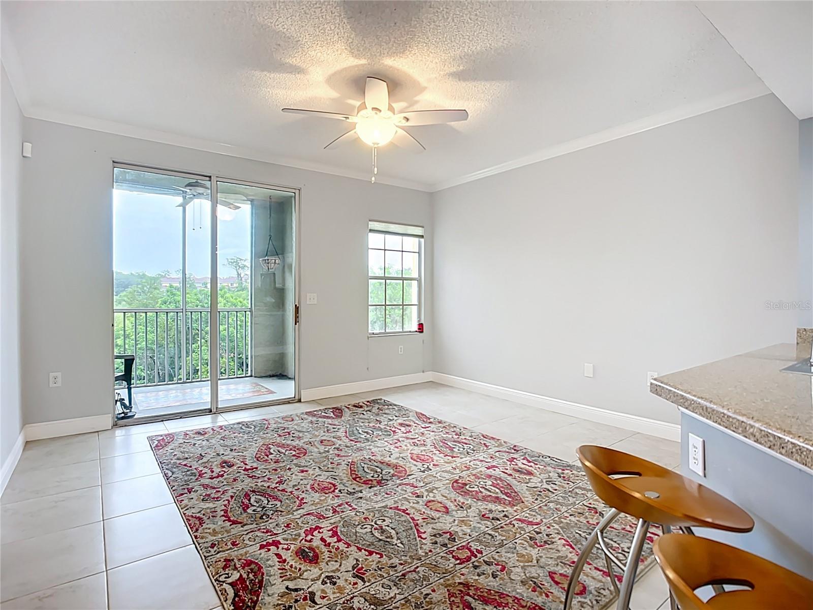 Living room has slider to screened lanai overlooking green spaces.