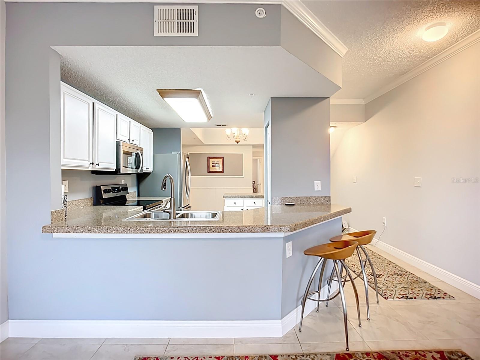 Breakfast bar with view through kitchen into dining room.