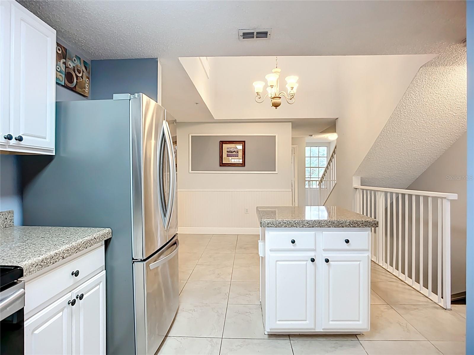 Kitchen view to dining room with soaring ceiling