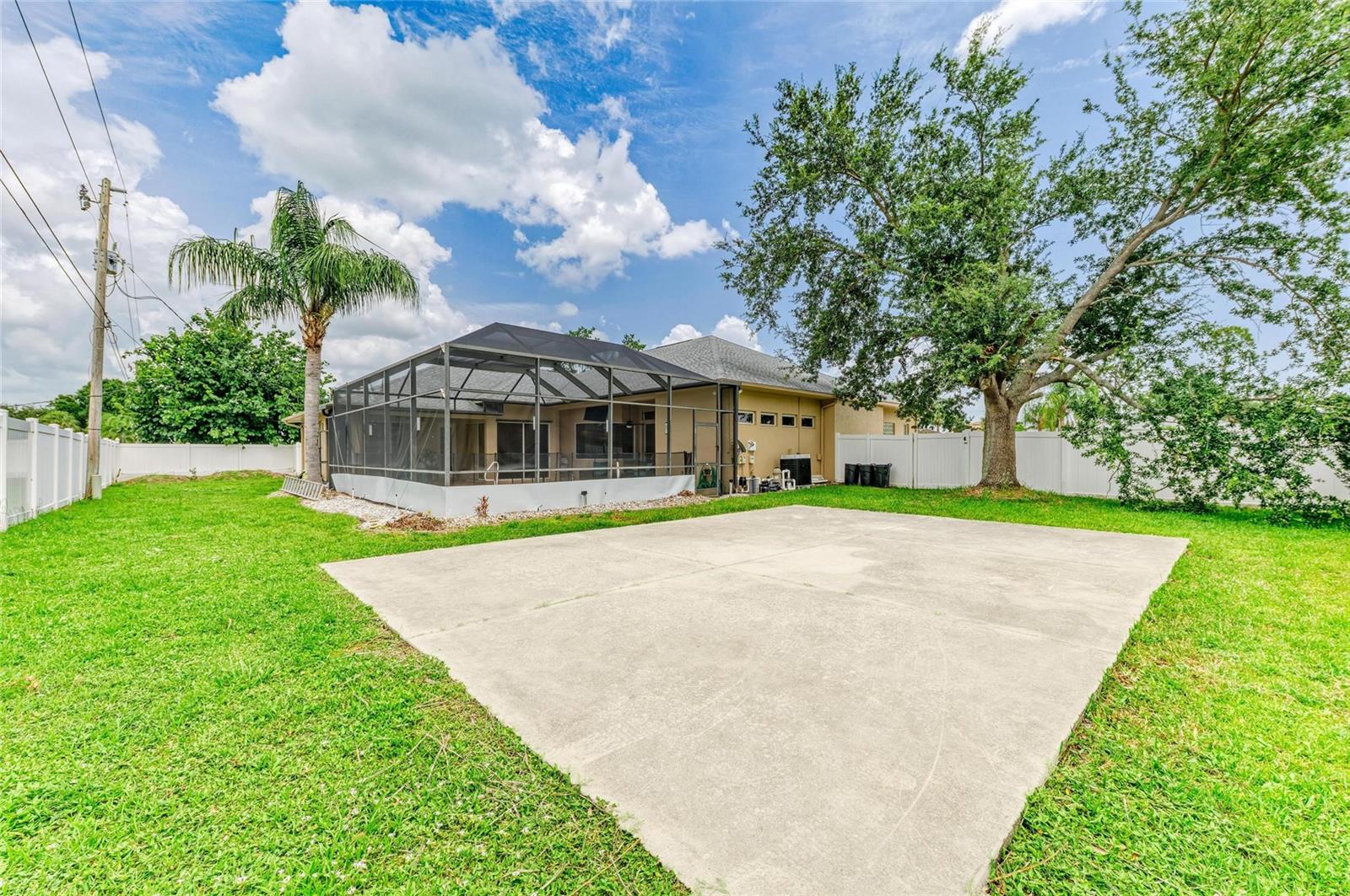 Backyard with cement pad: ideal for basketball or grilling.