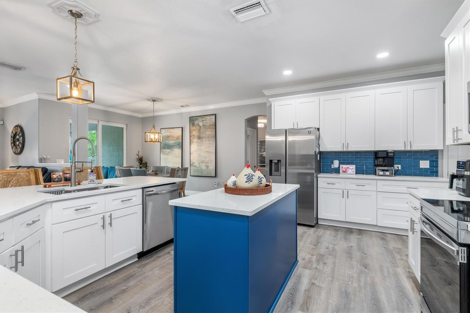 Upgraded kitchen with white shaker cabinets and accent color on island.