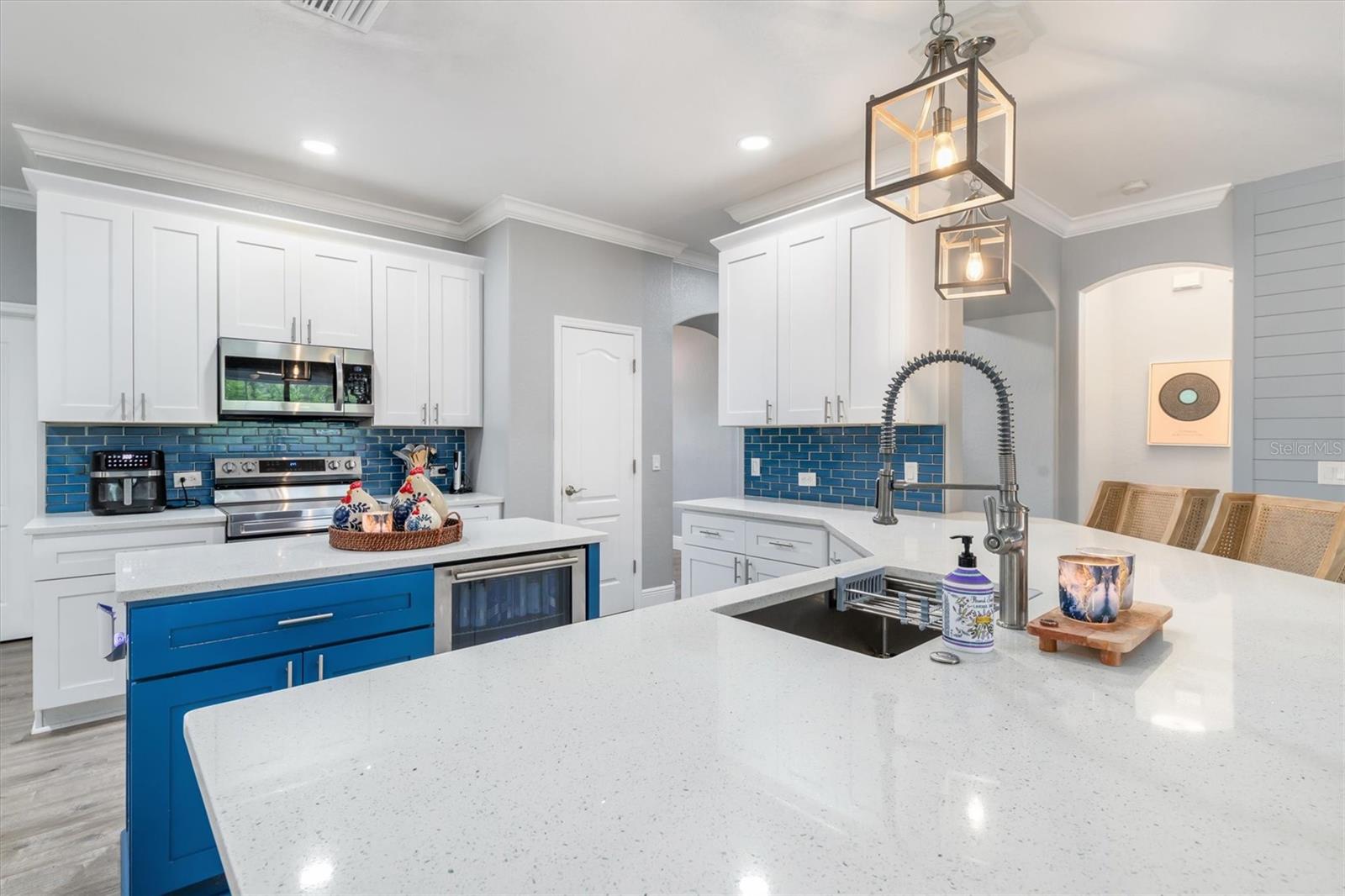 Chef's kitchen with range, microwave and subway tile backsplash.