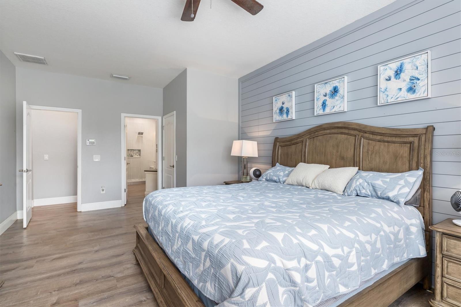 Primary bedroom has shiplap accent wall.