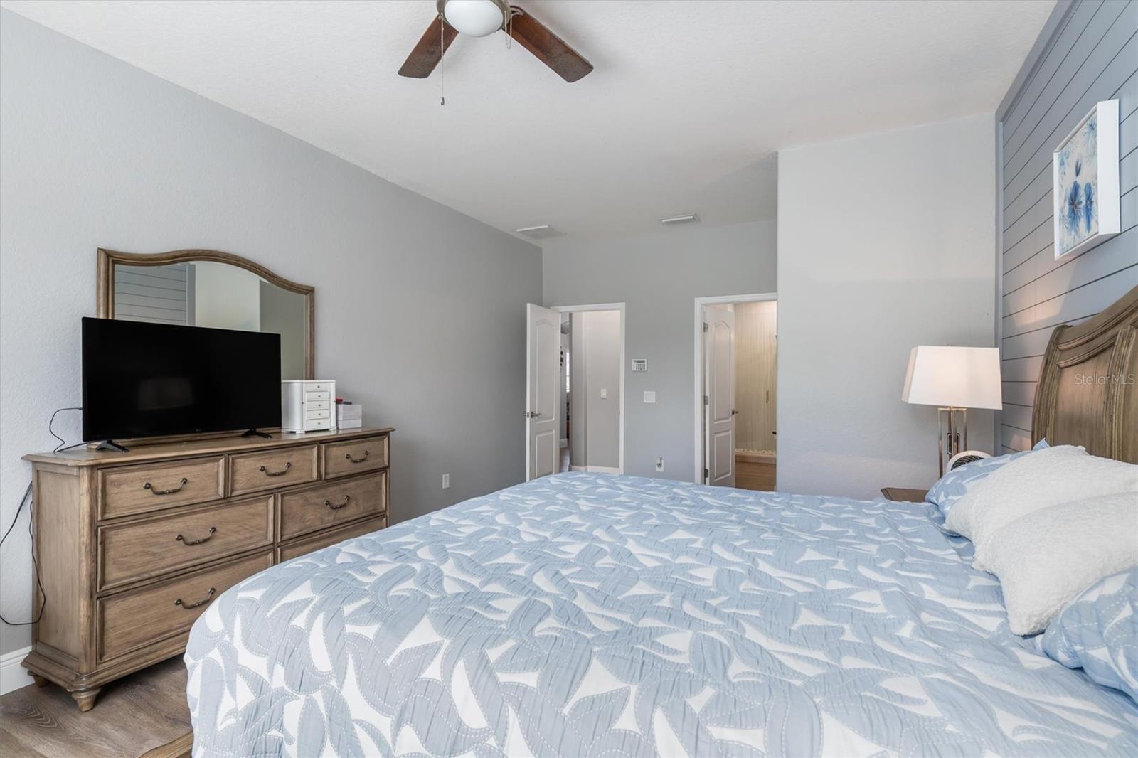 Spacious and light bedroom with fan and luxury vinly flooring.