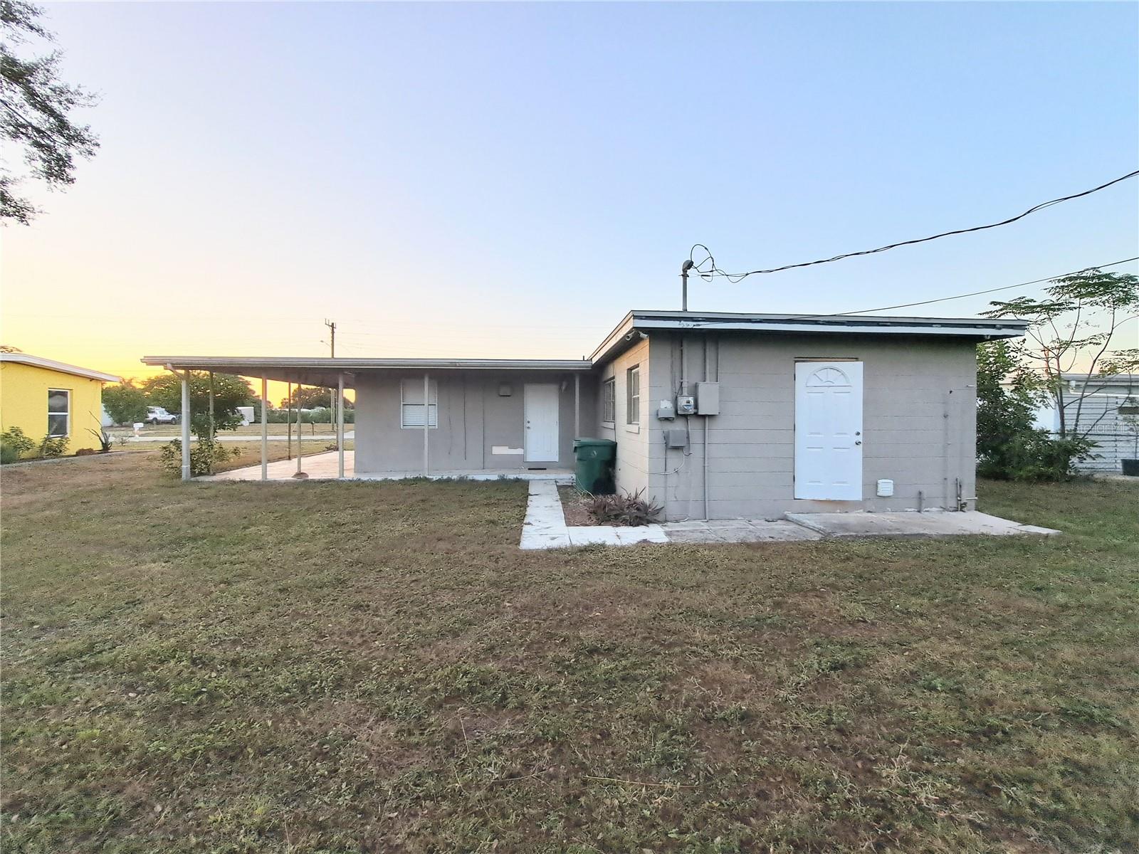 Rear yard view showing both exterior doors located at the rear of home.