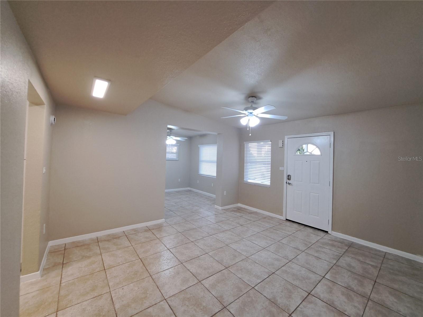 Front Living Room looking toward additional Living space, Kitchen on left, front Exterior door.