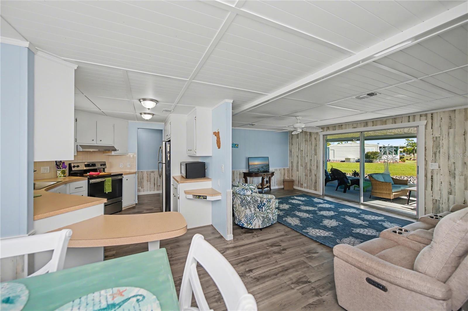 This picture displays how the kitchen, dining area and living room come together in a partial open floorplan.