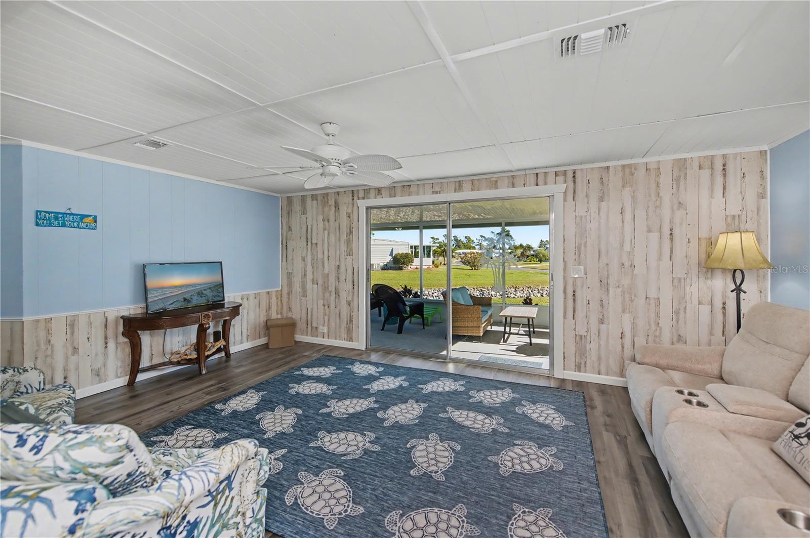 Spacious living room opens onto a large lanai overlooking the beautiful back yard and canal.