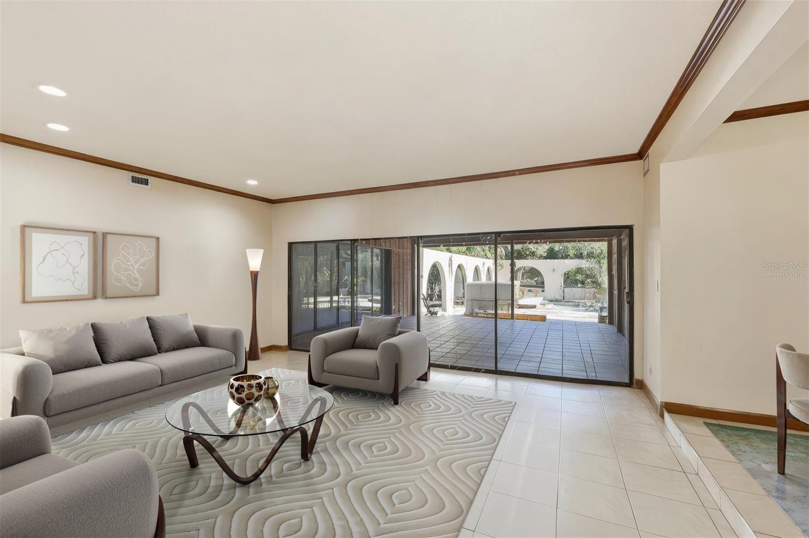 VIRTUALLY STAGED: Spacious Living Room with Sliders to Covered Lanai/Pool Area