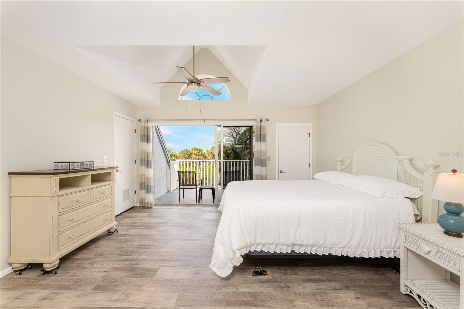 Primary bedroom is quite spacious, with sliding glass doors opening onto the balcony