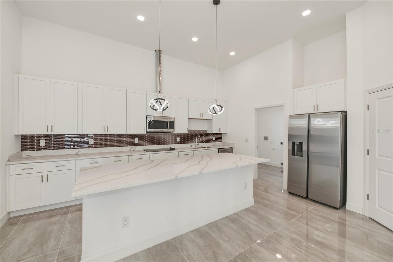 Chef's Kitchen with Oversized Quartz Waterfall Island.