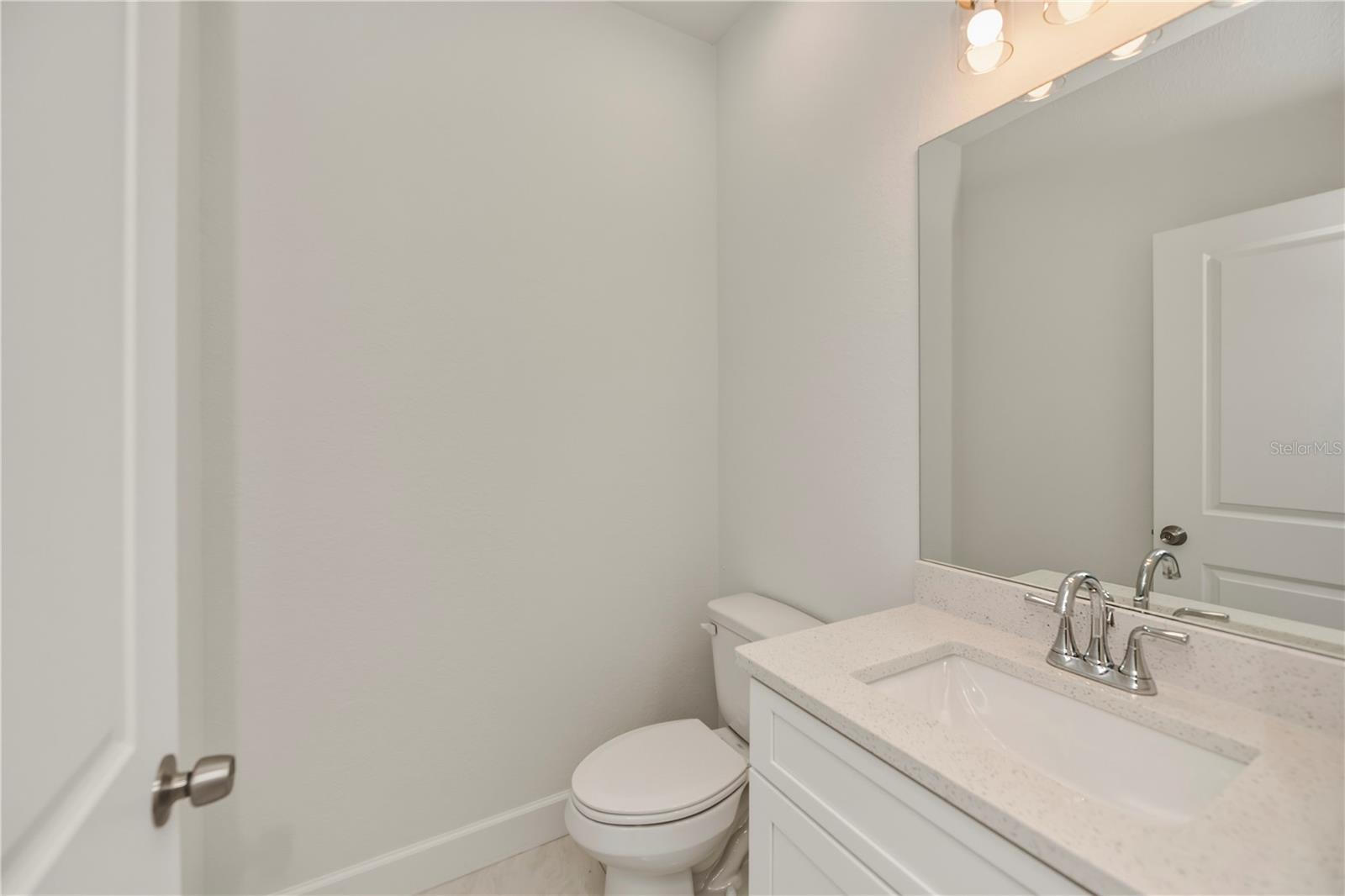 Convenient Half Bath with Quartz Vanity.