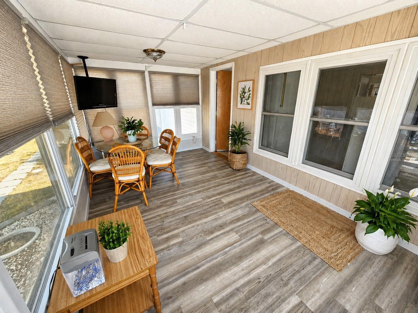 Florida room with a few chairs removed virtually staged