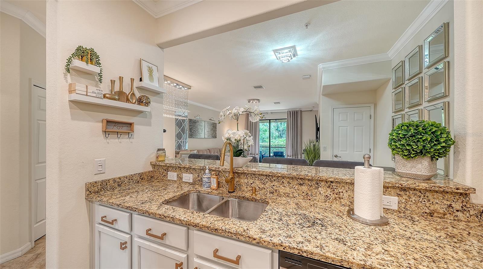 Kitchen view to Dining and Living area featuring solid wood cabinets, granite countertops