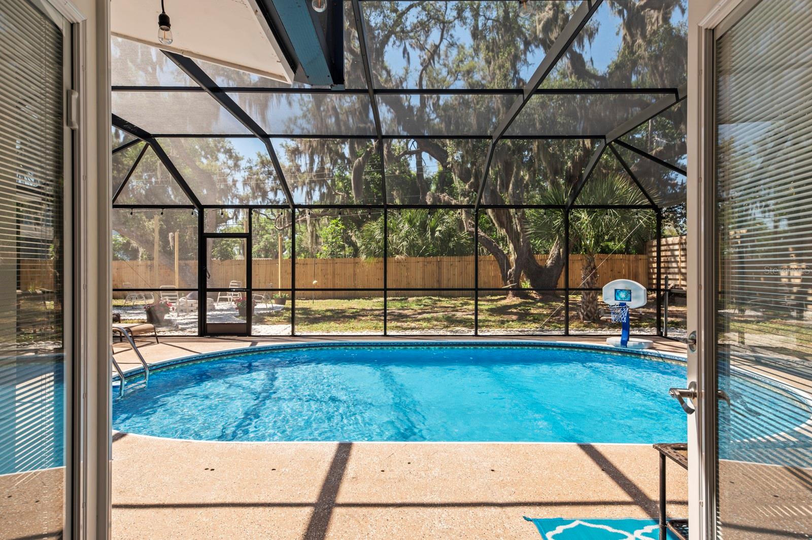 From the back door looking out over the pool into the back yard. Pool cage is now taken down.