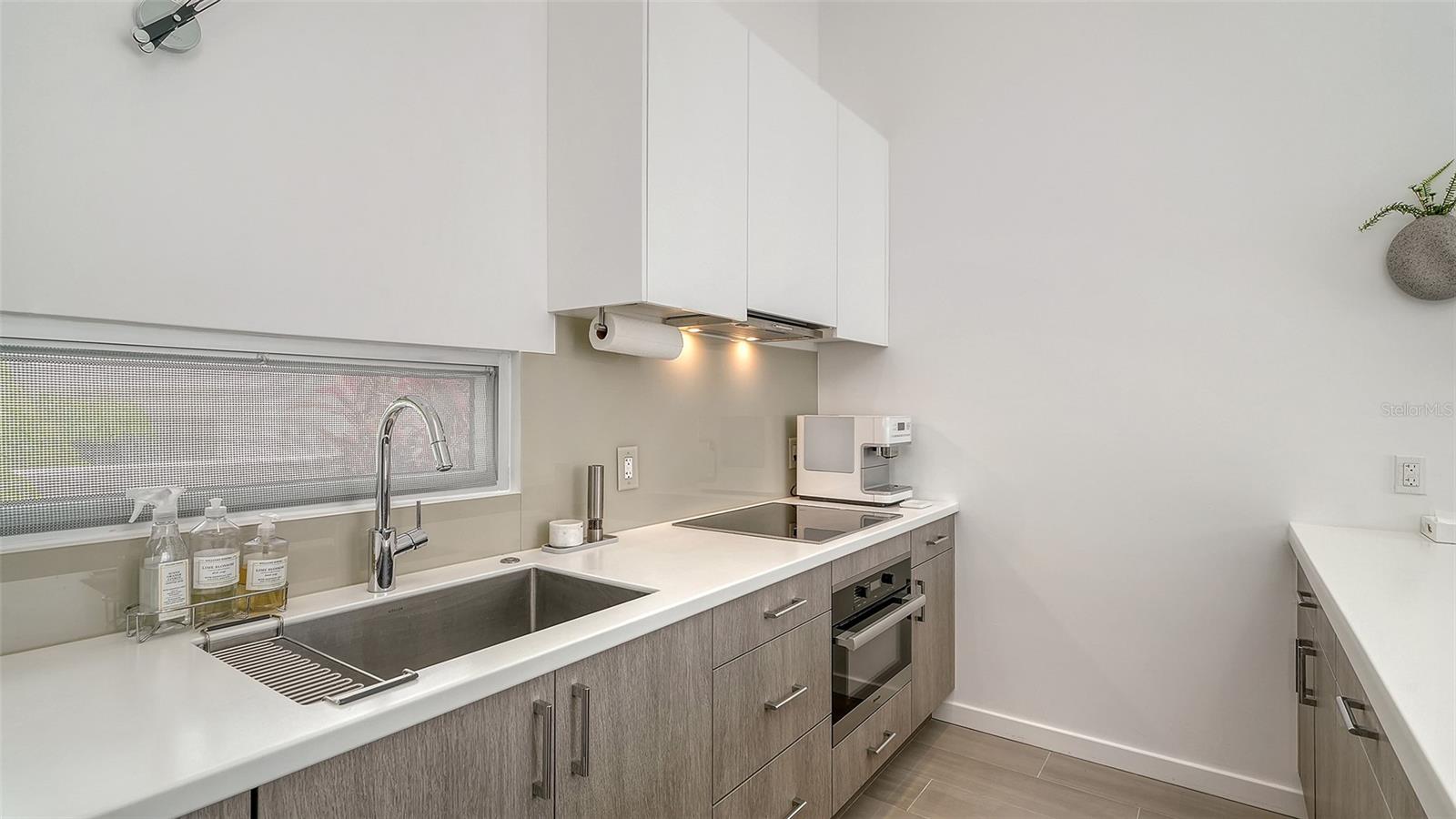 Roomy contemporary  bathroom with dual sinks and private toilet room.