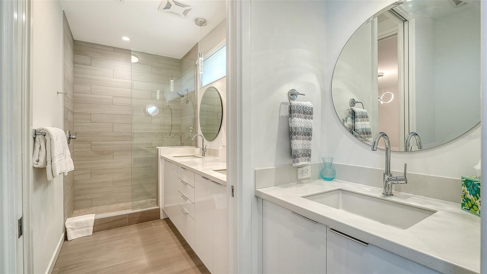 Modern bathroom with dual sinks and private toilet room provide bathing pleasure.