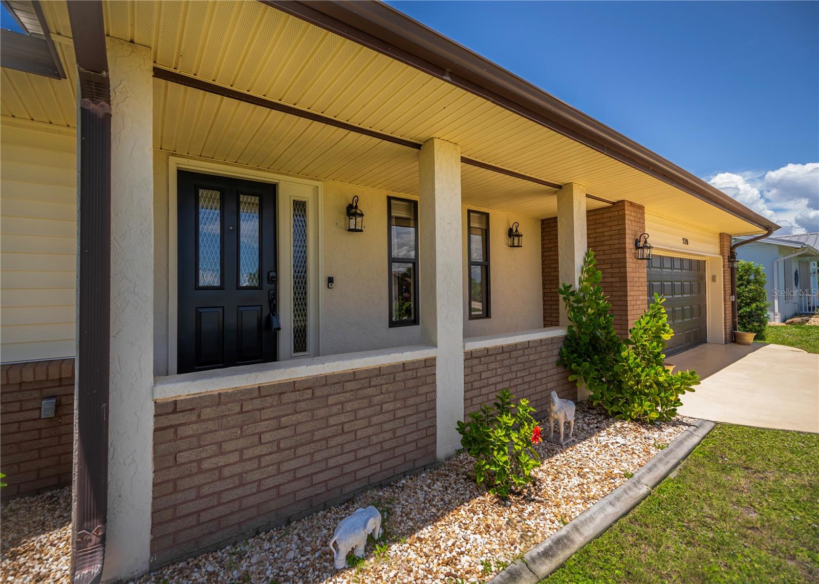 Covered Front Porch with Brick Accents.