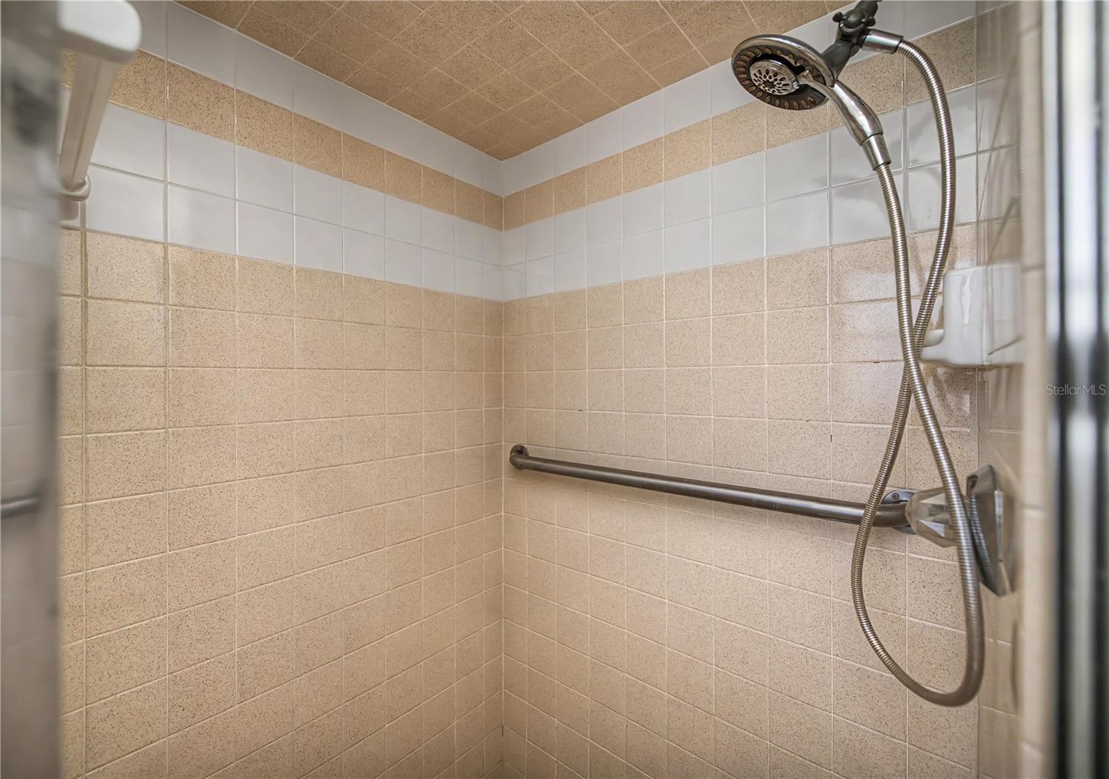Walk-In Tiled Shower with Grab Bar.