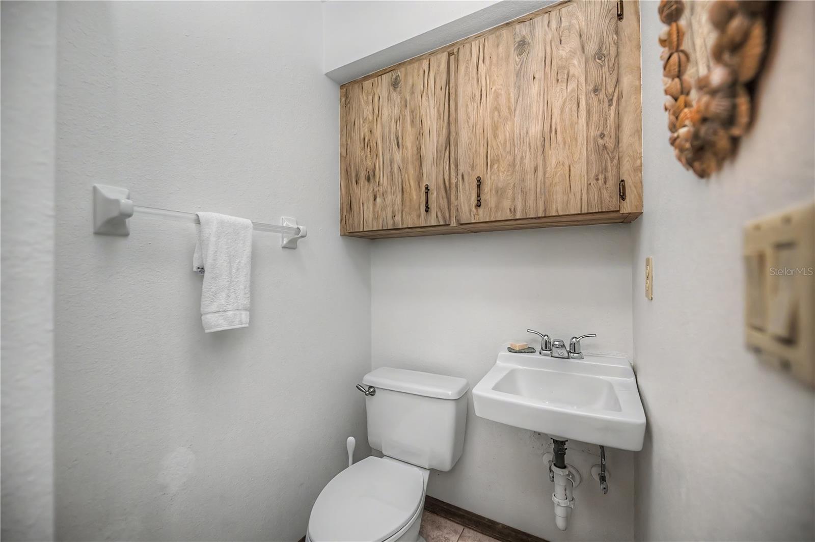Third Bathroom with Vanity Sink and Overhead Storage Cabinets.