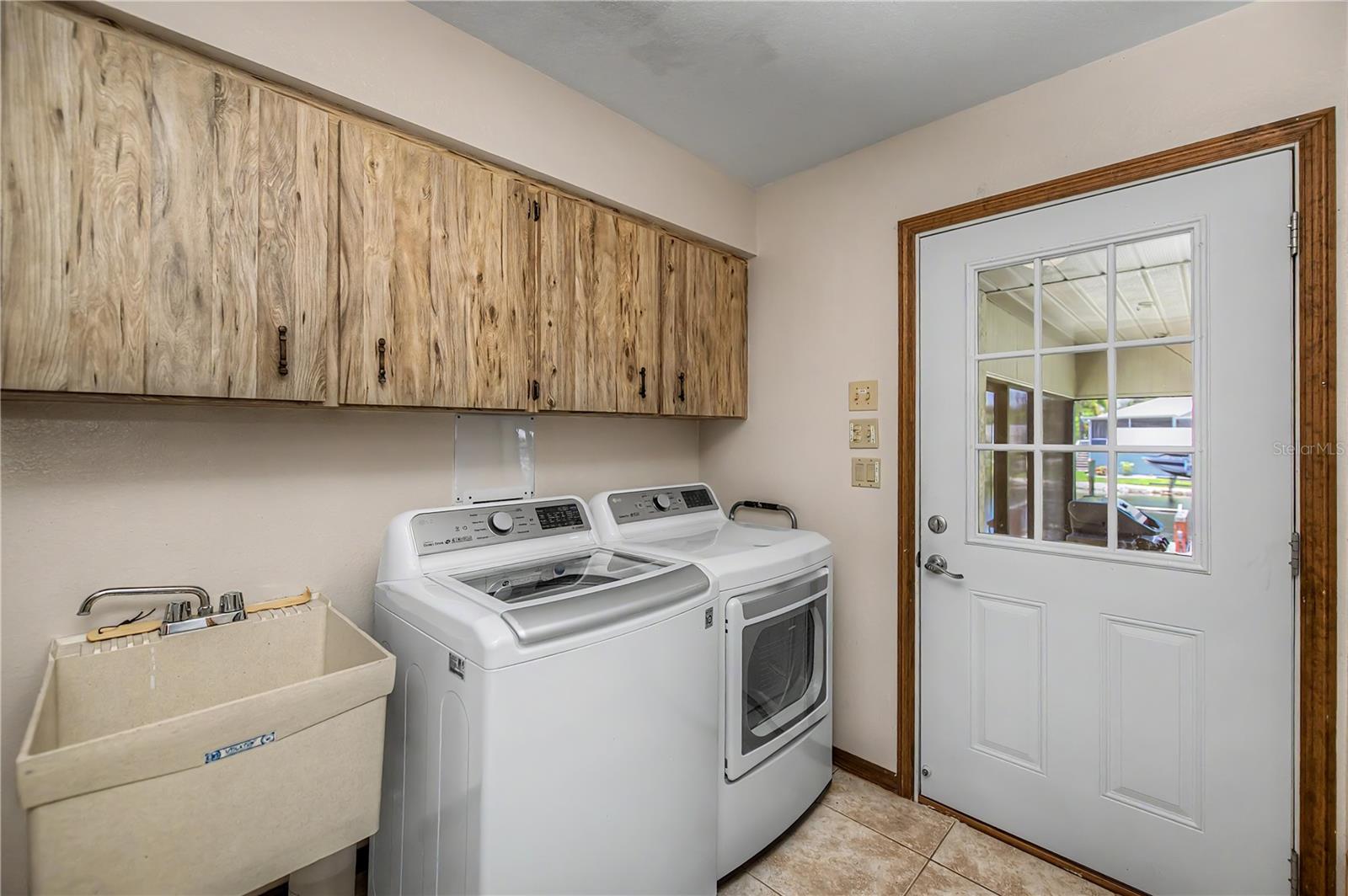 Laundry Room with Utility Sink and Storage Cabinets.