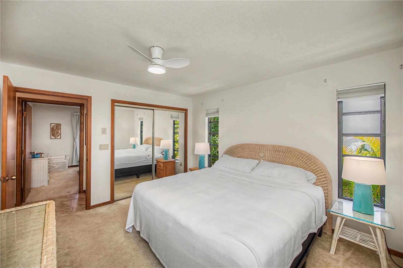Spacious Primary Bedroom with Ensuite Bath and Mirrored Closet Doors.