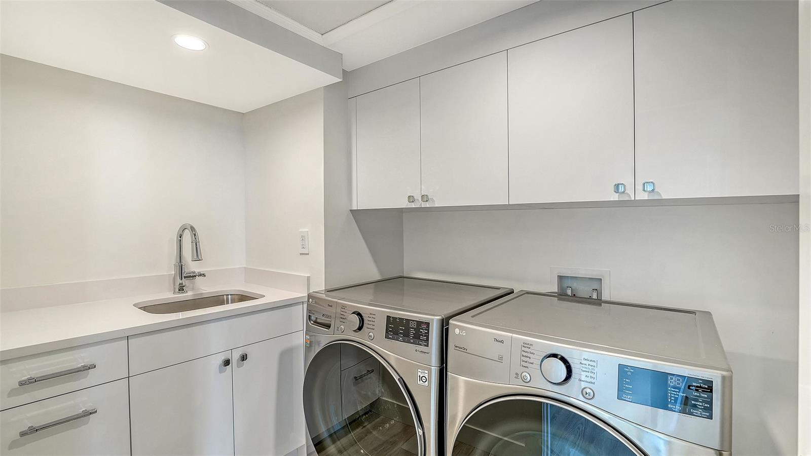 Full sized laundry room with wash sink