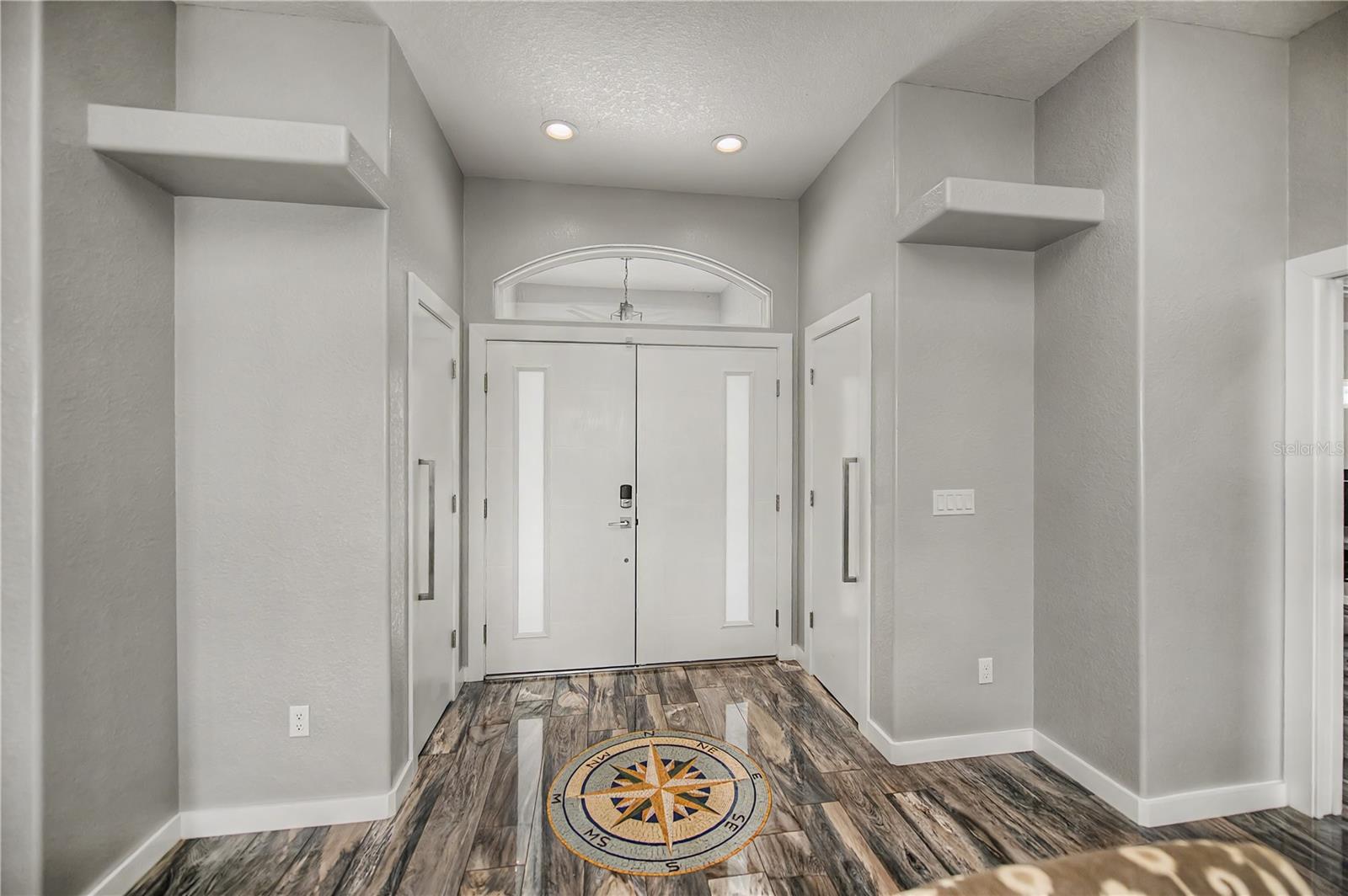 Light-Filled Foyer Featuring Designer Flooring and Welcoming Grand Entrance.