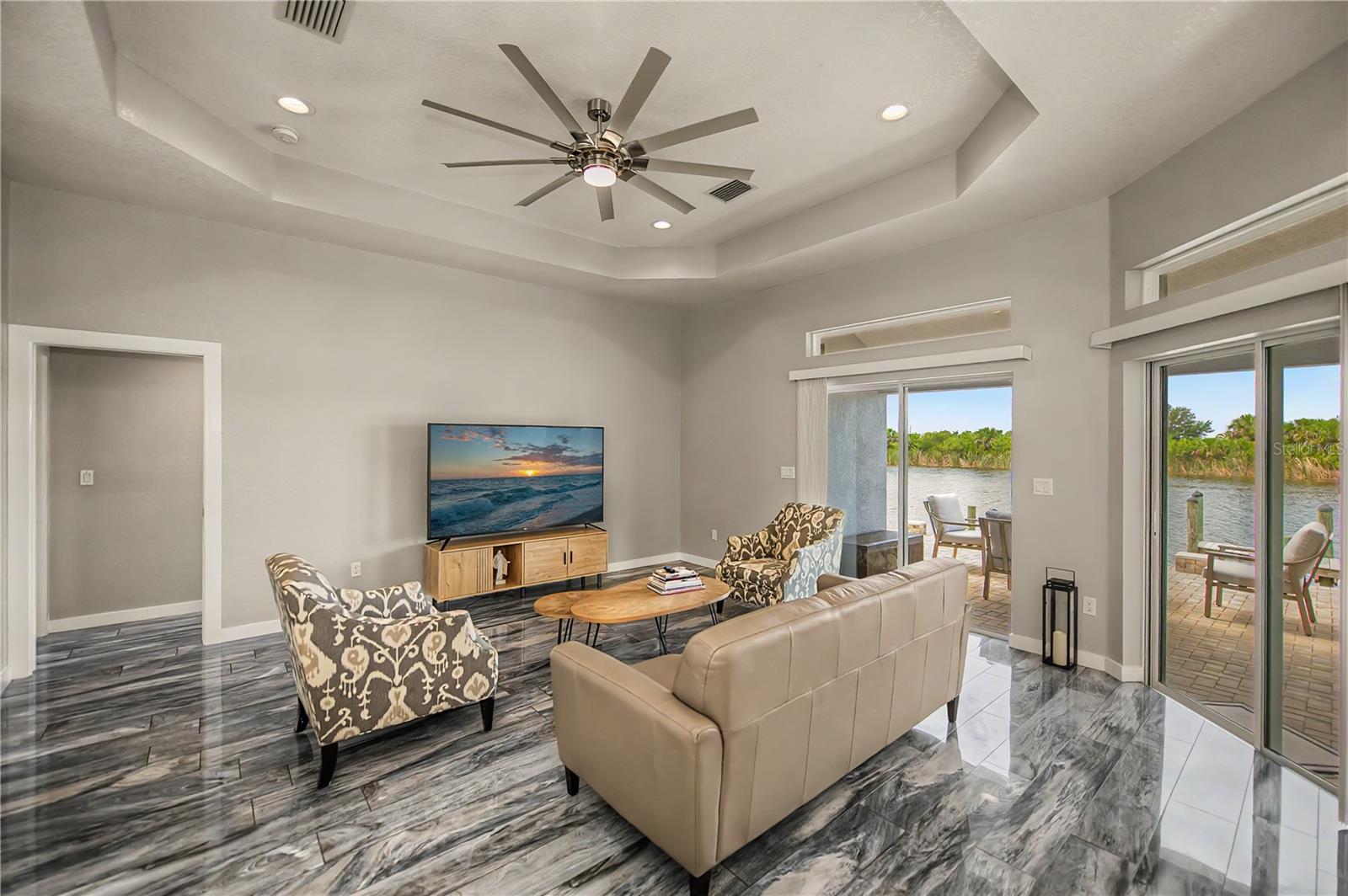 Living Rooms has Soaring Tray Ceilings, Designer Flooring, and Seamless Access to the Waterfront Patio.