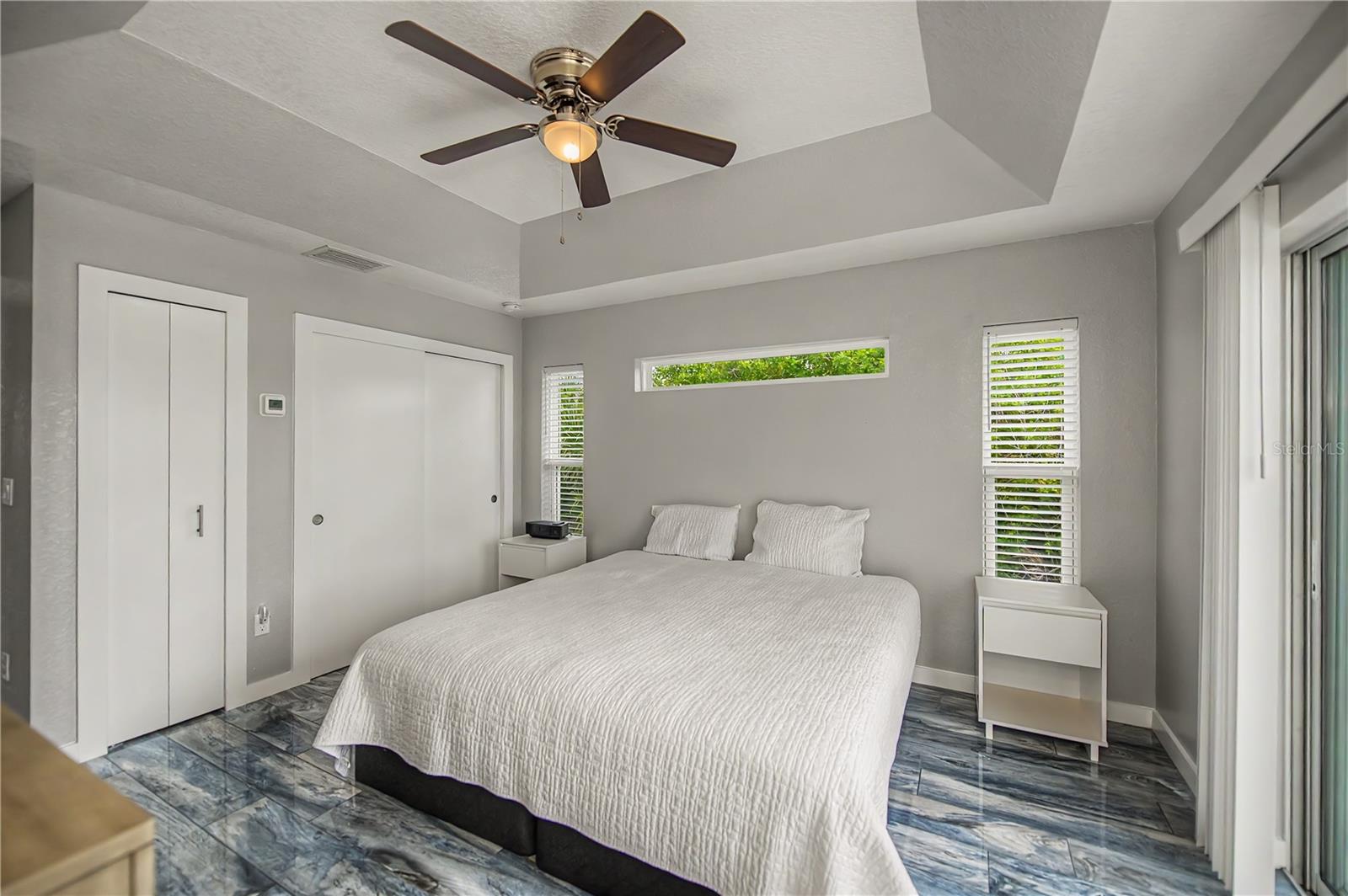 Guest Suite with Tray Ceiling, Patio Access, and Generous Closet Space.
