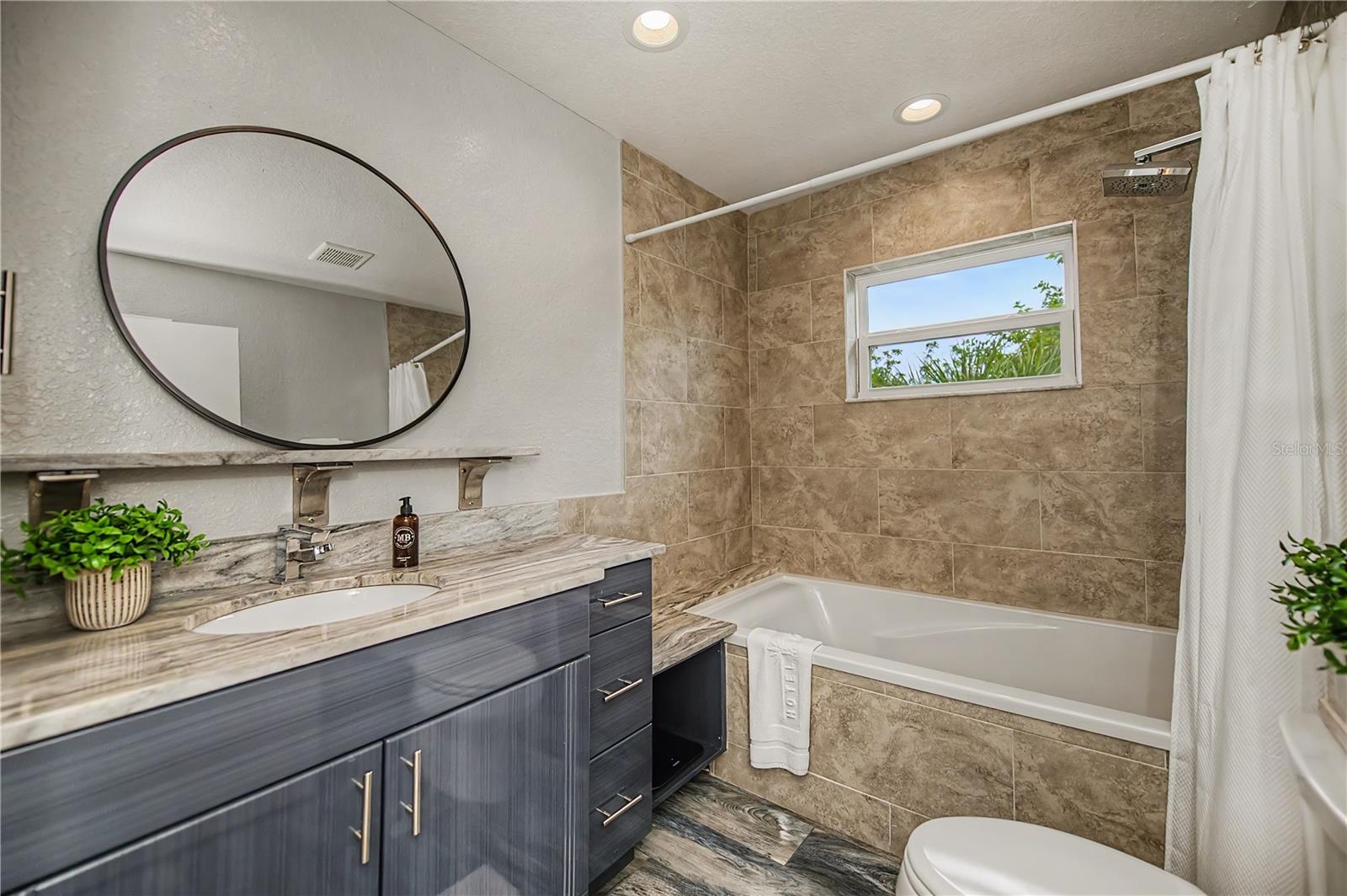 Well-Appointed Guest Bath Featuring a Spacious Vanity and Tiled Tub/Shower Combo.