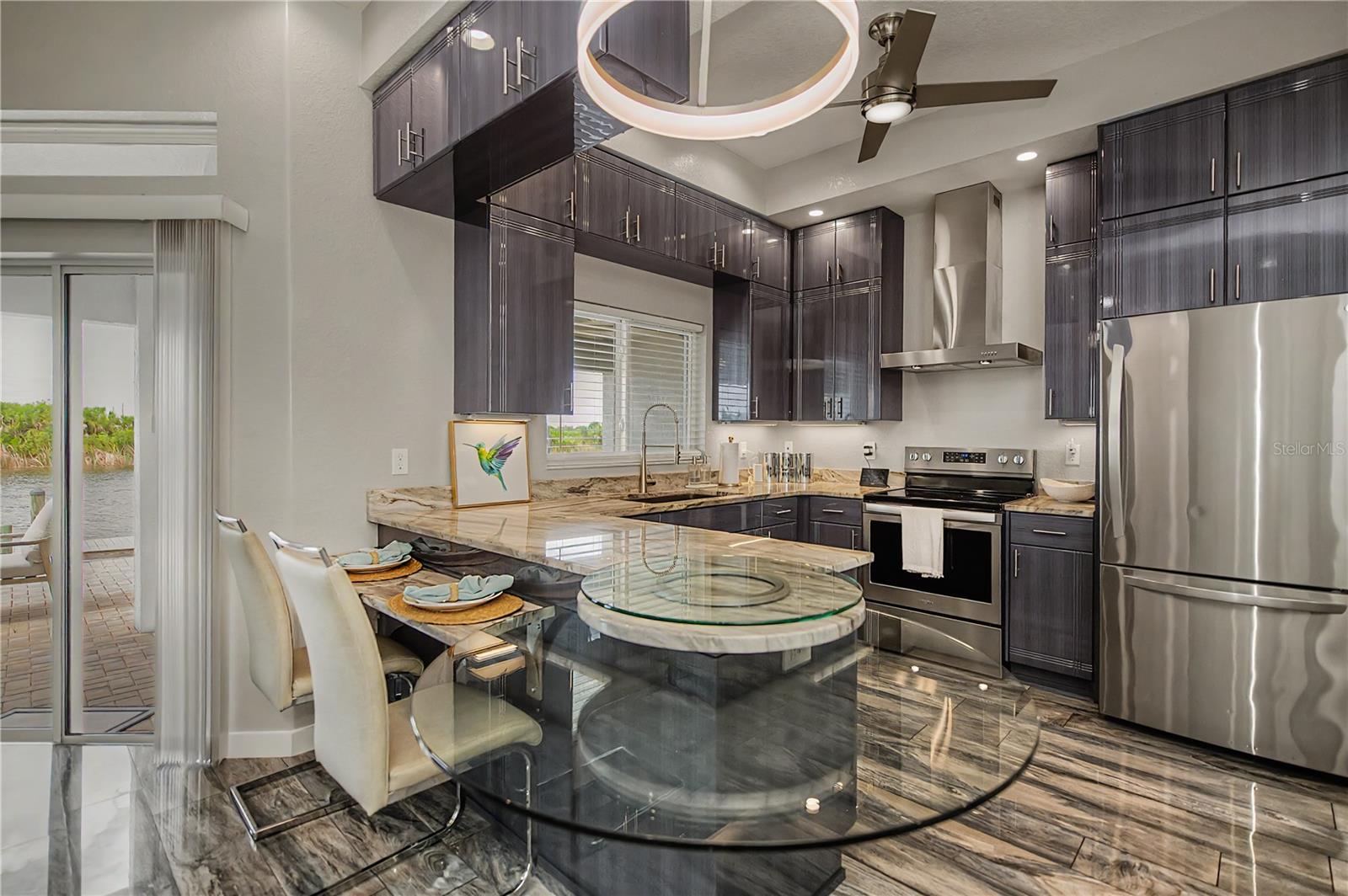 Designer Kitchen with Custom Cabinetry, Stone Countertops, and a Unique Glass-Accent Breakfast Bar.