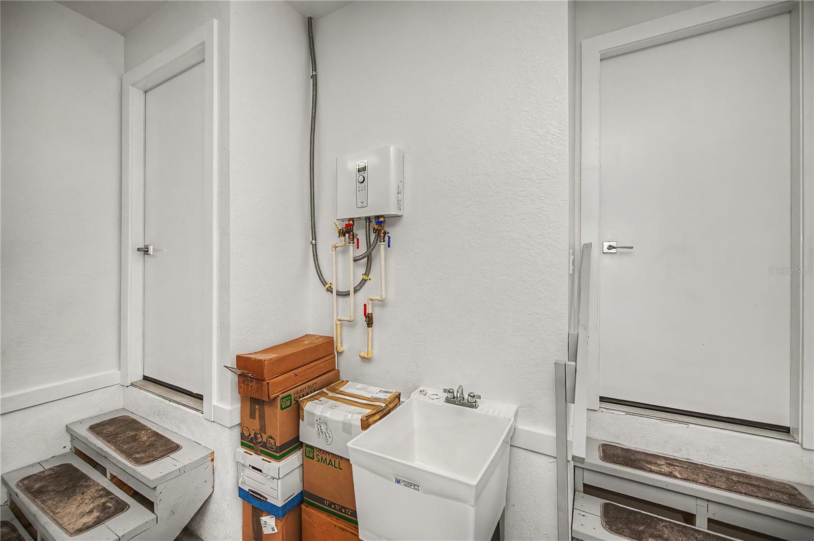 Generator Hookup outside, Functional Utility Area Featuring an Instant Hot Water System and Convenient Utility Sink.
