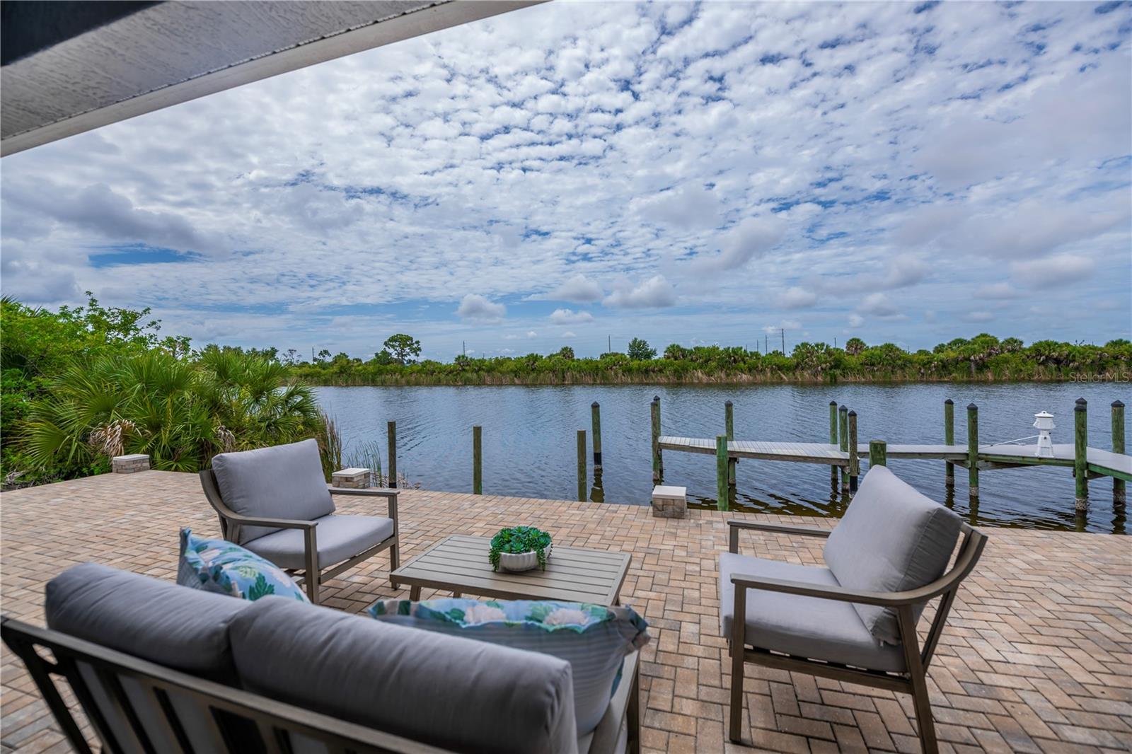 Waterfront Patio with Paver Deck, Private Dock, and Serene Canal Views.