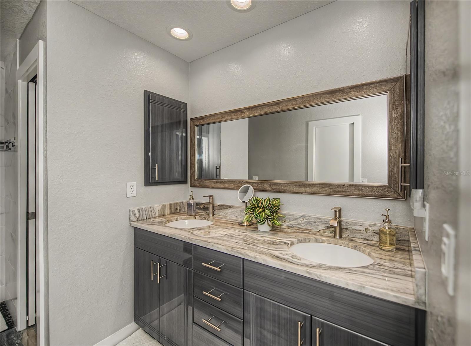 Primary Bathroom, Dual Vanities, Designer Finishes, and Luxurious Stone Countertops.