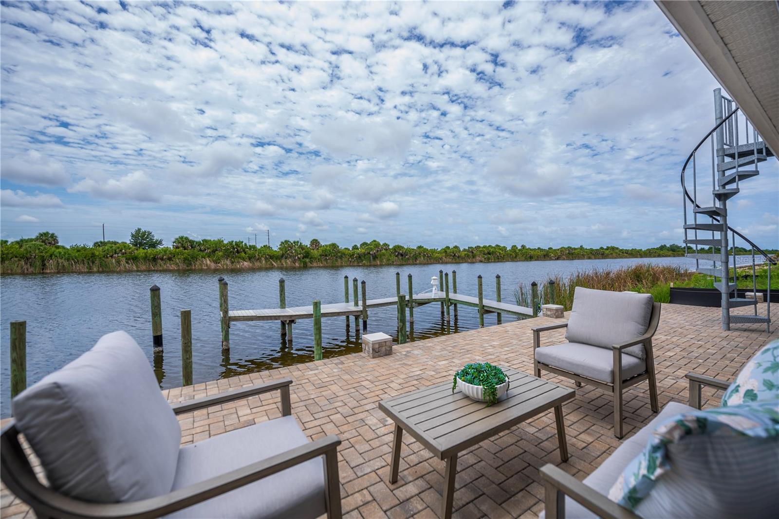 Waterfront Patio Retreat with a Private Dock, Spiral Staircase, and Wide Water Views.