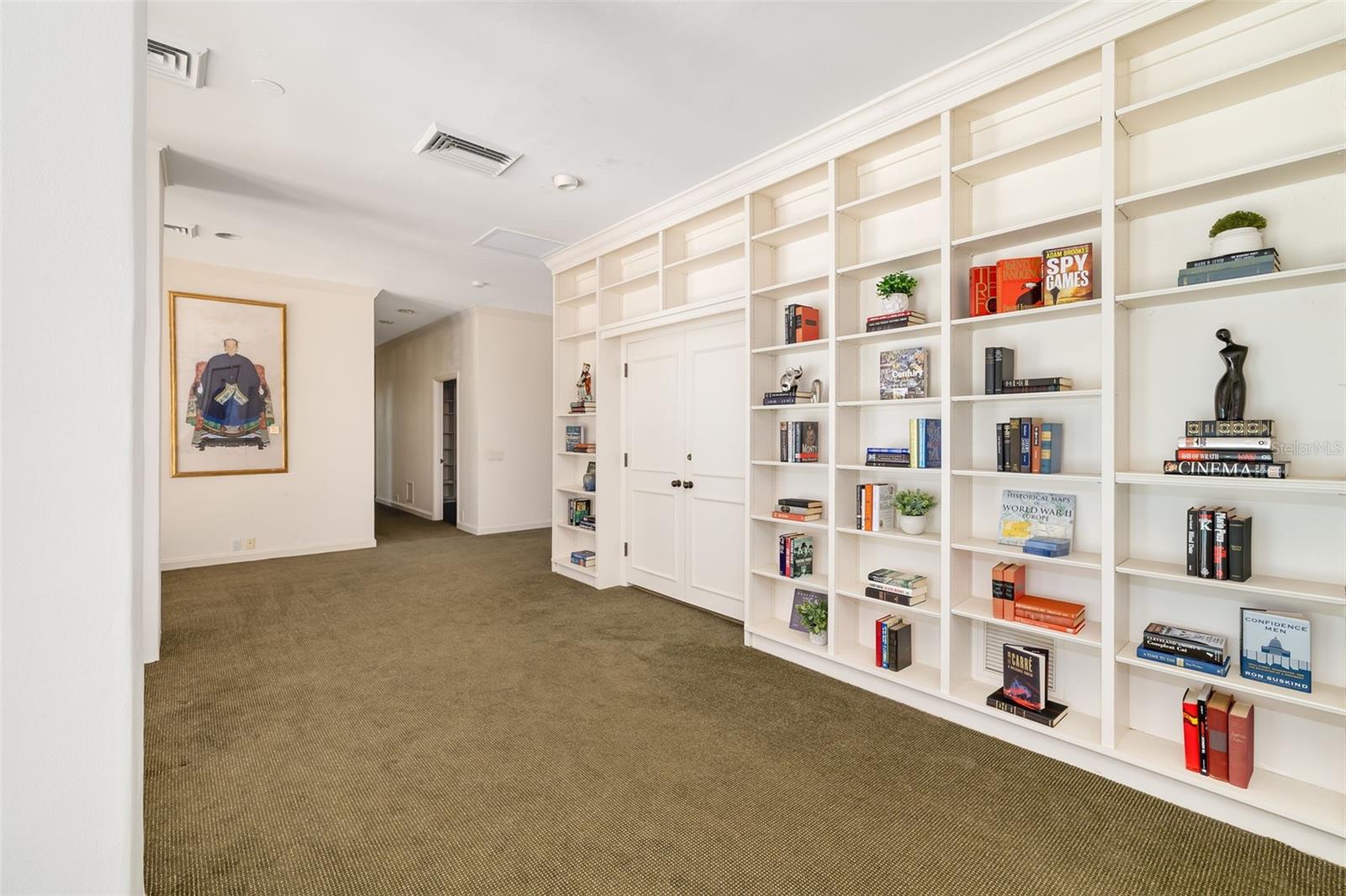 Behind the bookshelves the homeowners used this room as an office, however it could be an additional bedroom and the other door shown open was used as a home gym.  Two additional bedrooms with terraces down the hall.