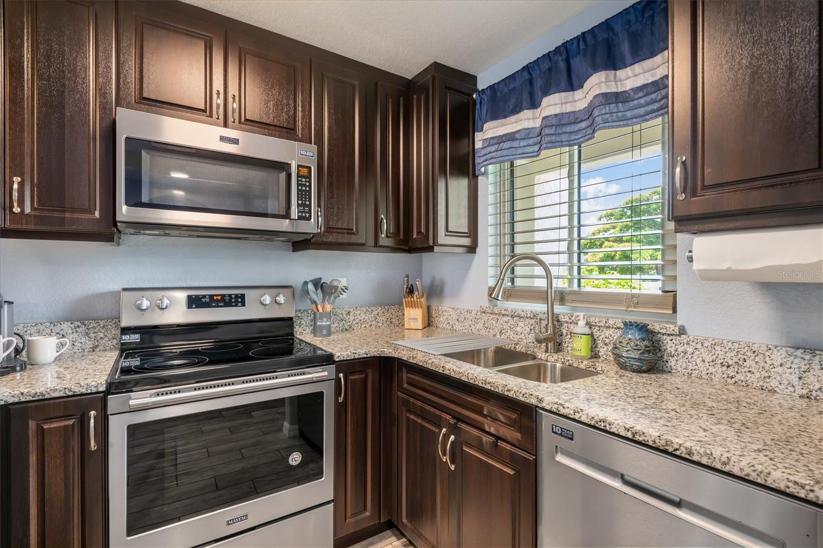 Espresso cabinets, granite countertops and a Maytag stainless steel appliance suite.