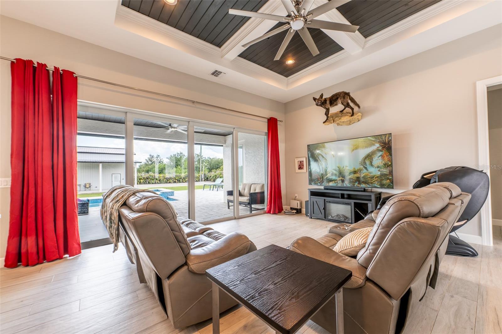 Another look at the expansive living room, emphasizing the wall of multi-slide glass doors that completely open to the pool deck. Experience the absolute best of true Florida indoor-outdoor living from the comfort of this light-filled, open-concept great room.