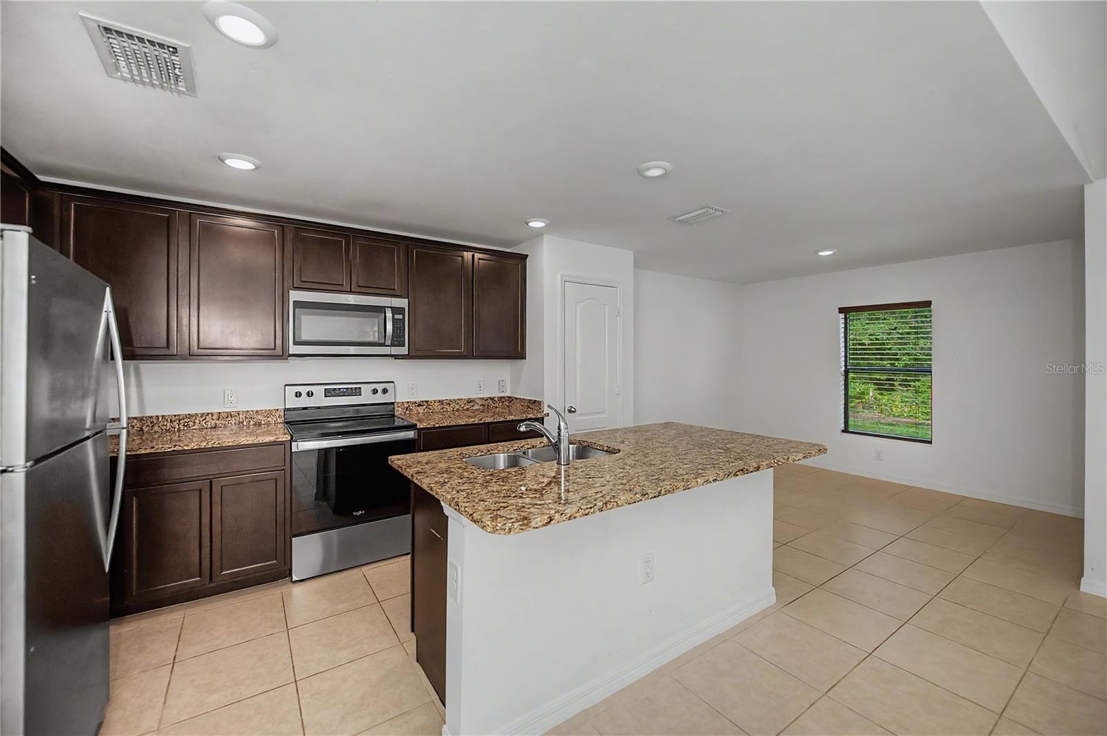 Open Kitchen with Granite Breakfast Bar and Stainless Appliances