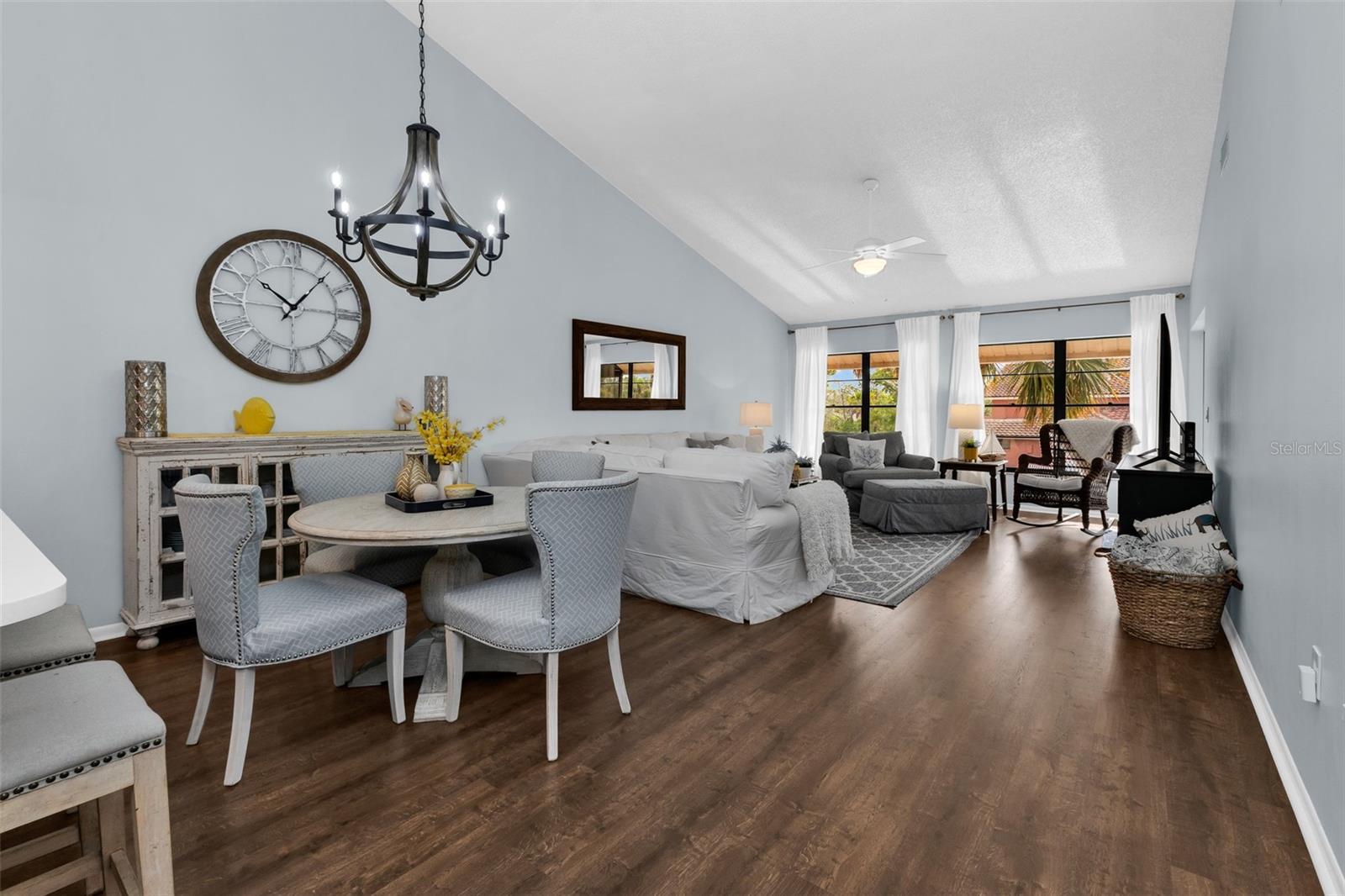 Dining room flows into the living room with updated light fixtures and laminate flooring.
