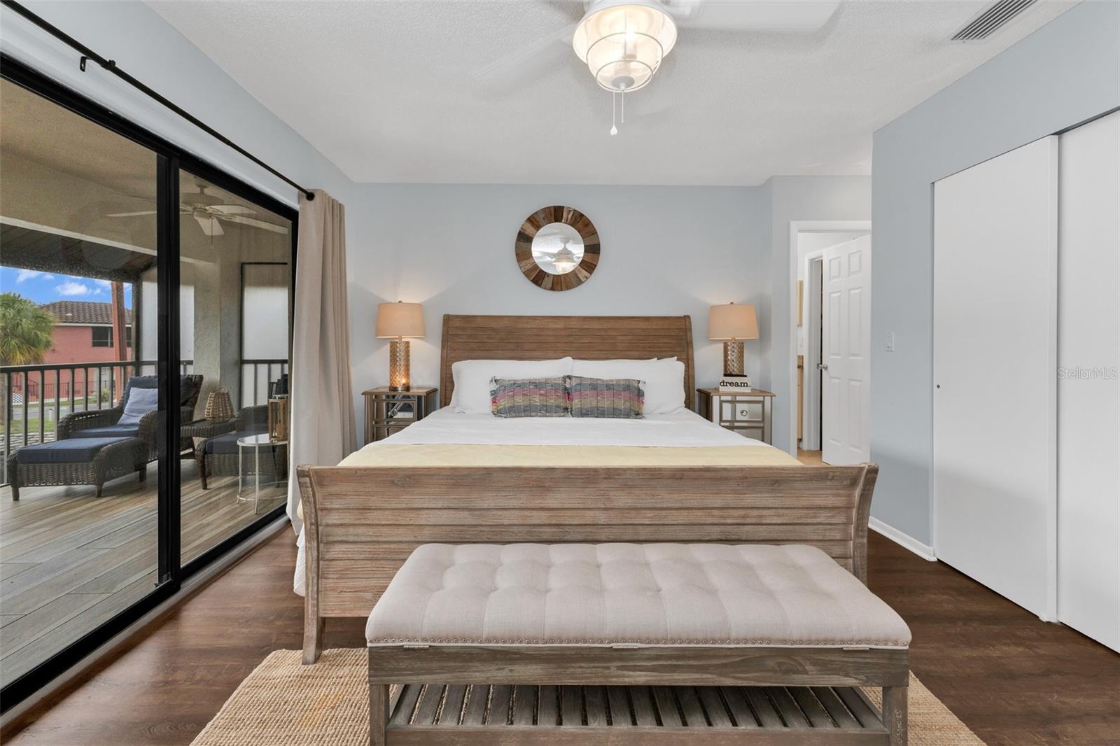 Primary bedroom features laminate flooring and sliders to the lanai.