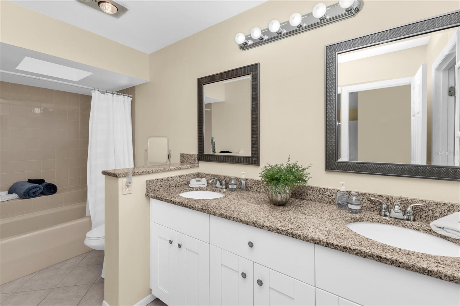 Primary bath with dual sinks, and a shower/tub combo.