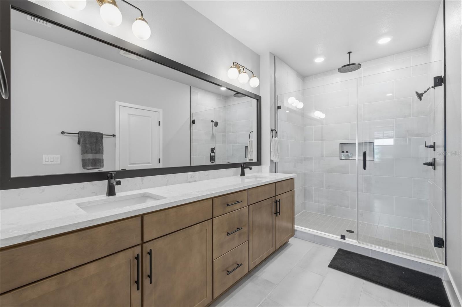 Primary en suite with dual Quartz vanity, seamless glass shower with double shower heads including rainfall