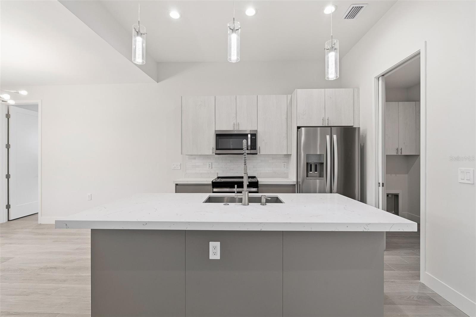 Sleek Kitchen with Quartz Island and Two-Toned Cabinetry
