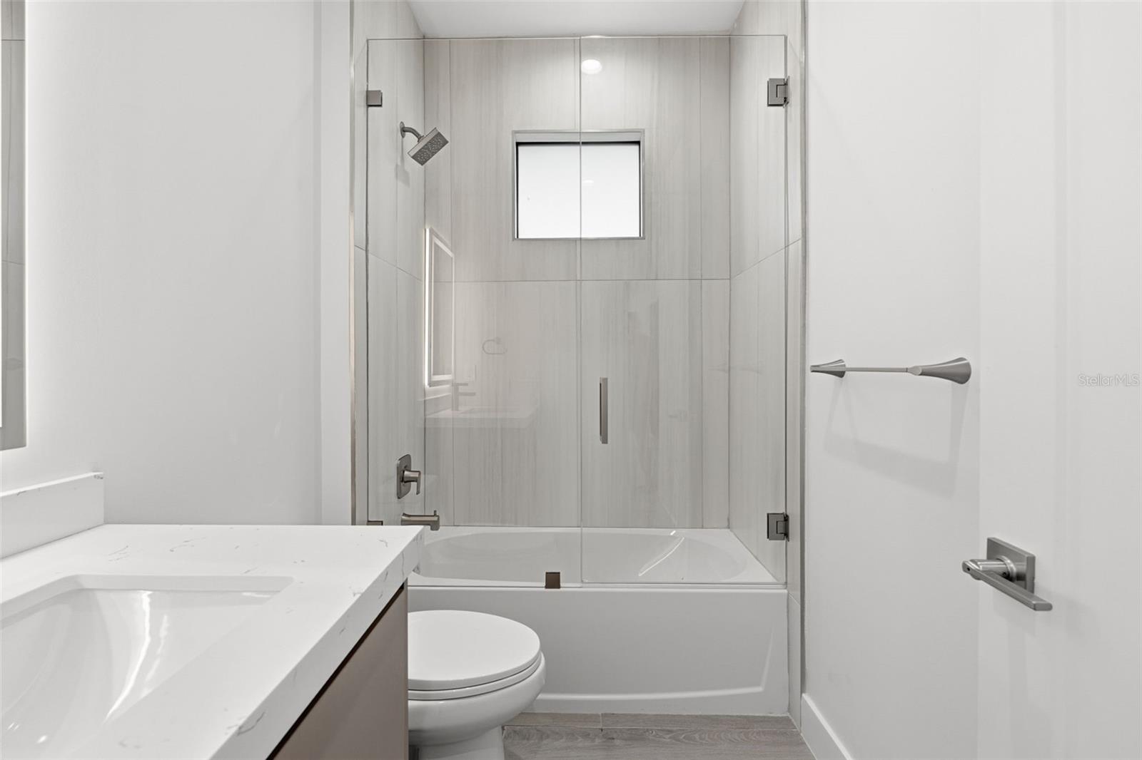 Guest Bathroom with Quartz Vanity and Tub/Shower Combo with Glass Enclosure