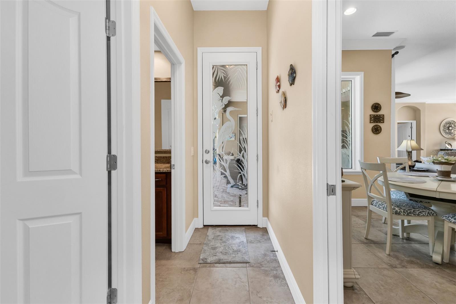 Pocket door leads to guest rooms plus pool access behind the etched glass door