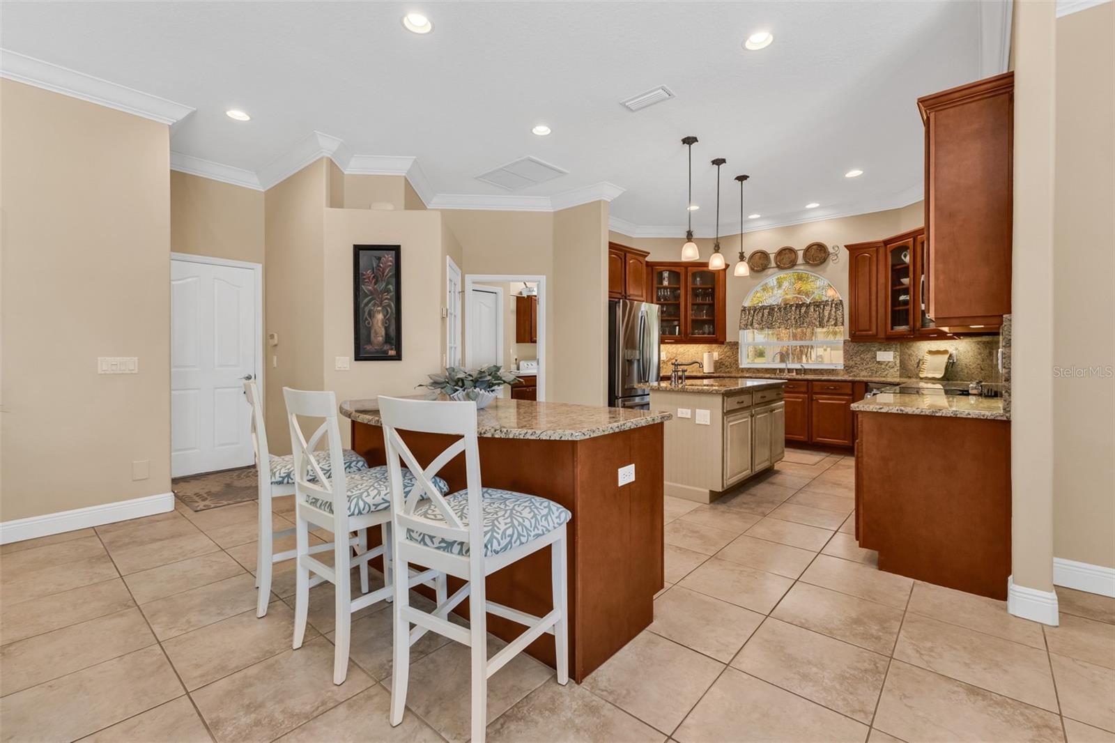 Door to the three-car garage sits off the kitchen and adjacent to the walk-in pantry shown to the right