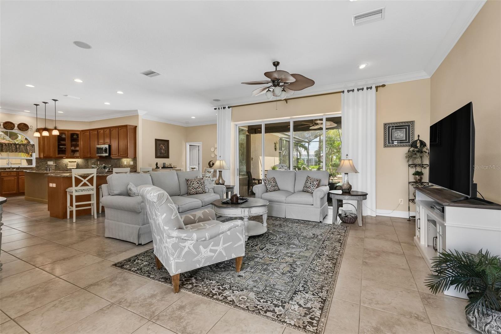 Tile flooring, 10ft ceilings and pocketing 4 panel sliding doors that open to the Pool/Lanai