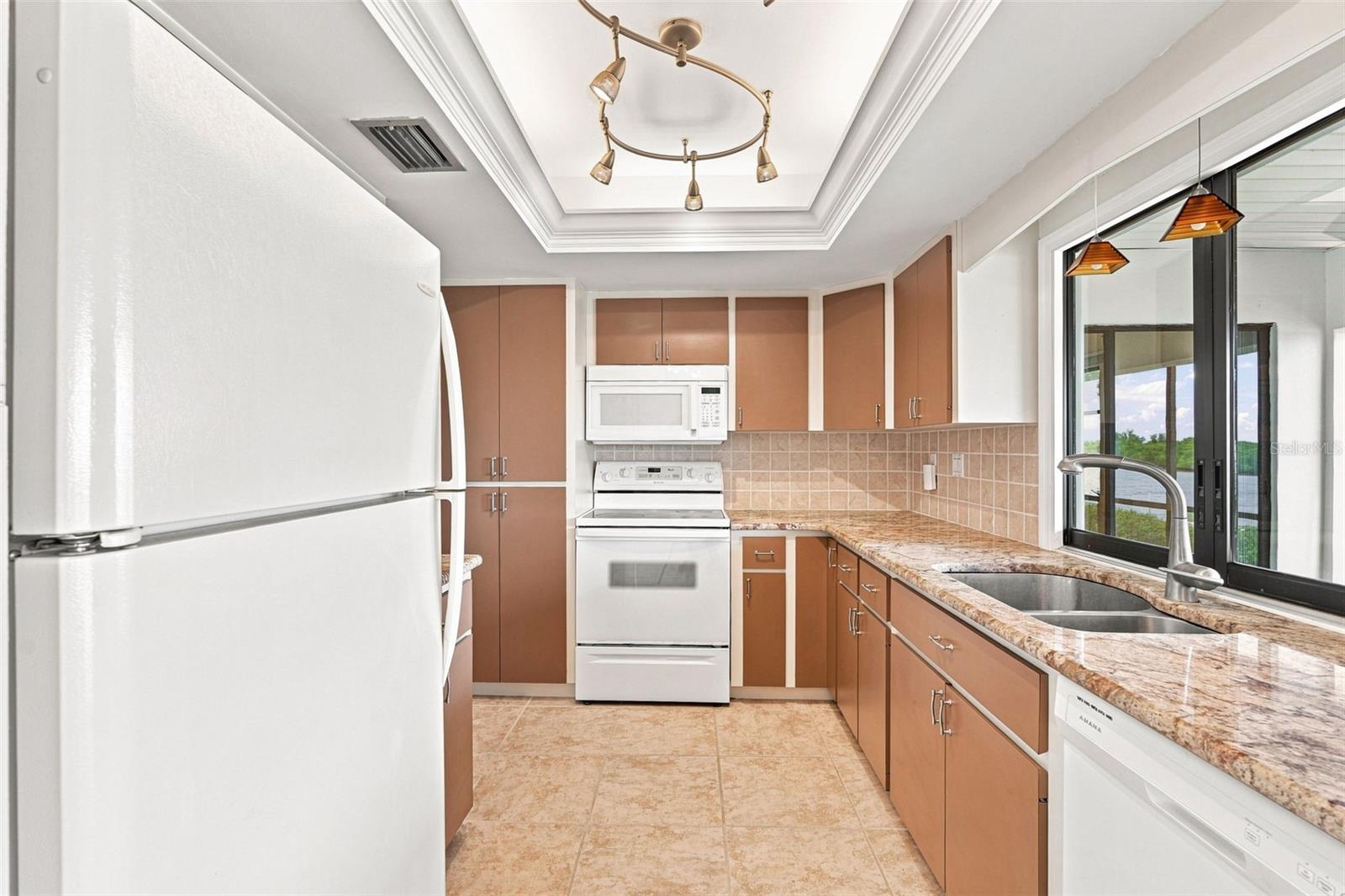 Kitchen Featuring Tray Ceiling, Crown Molding and Scenic Water Views